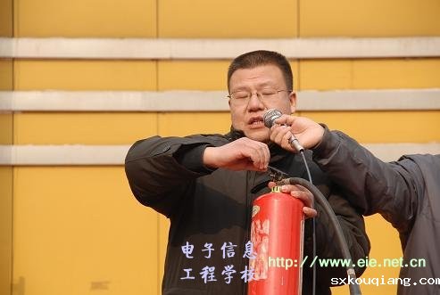 政教处副主任席明闰演示灭火器的使用方法