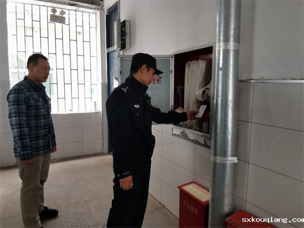 图为郭警官检查学校消防设施.jpg
